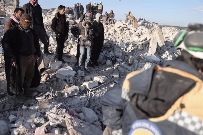 Civiles observan las labores de rescate en uno de los edificios derrumbados por el terremoto.