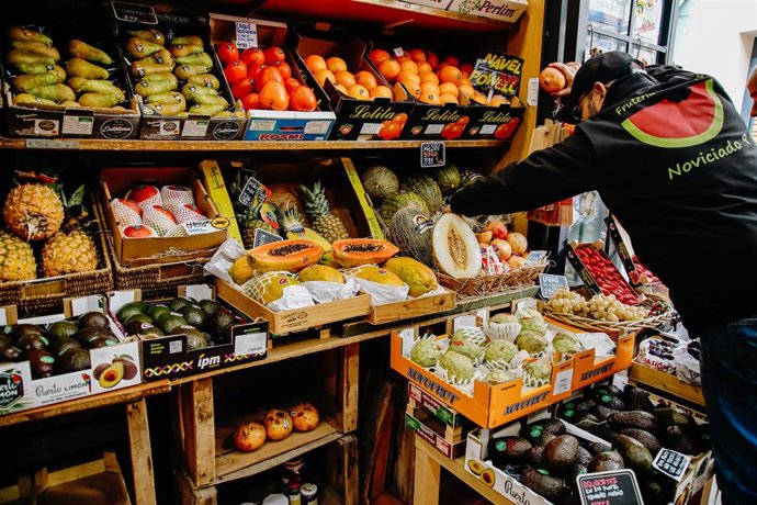 Archivo - Un empleado coloca varios melones en una frutería.