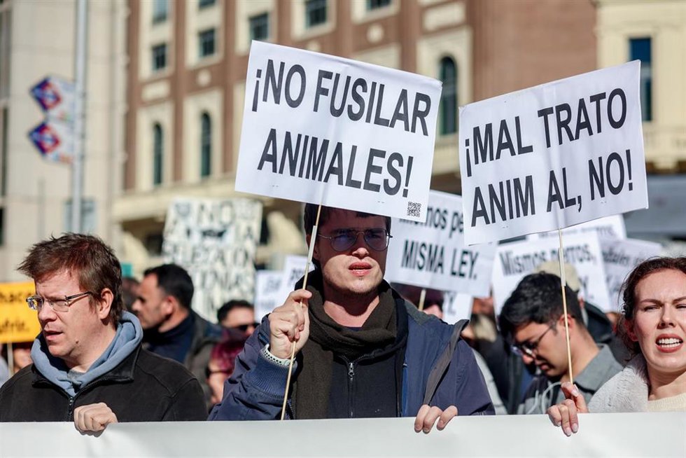 Un grupo de personas sujetan pancartas en una concentración bajo el lema No a la caza, en Madrid