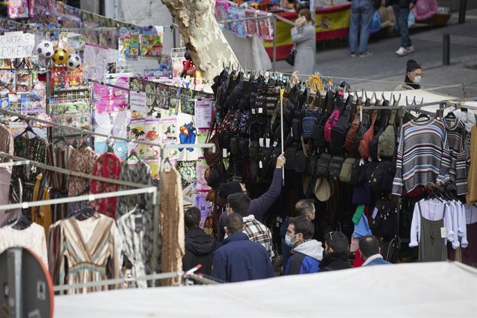 Archivo - Varias personas visitan los puestos en El Rastro de Madrid.