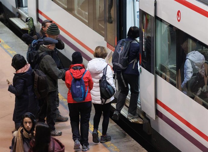 Varias personas sin mascarilla se suben a un vagón de un tren en la estación Puerta de Atocha-Almudena Grandes, a 8 de febrero de 2023