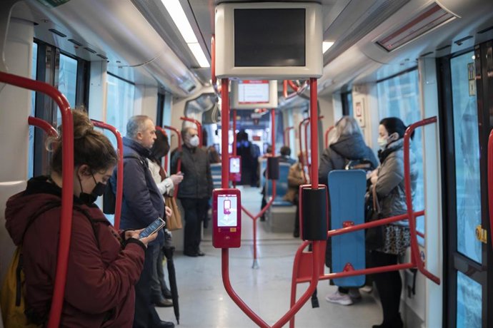 Varias personas con y sin mascarillas en el interior de un tranvía en Sevilla