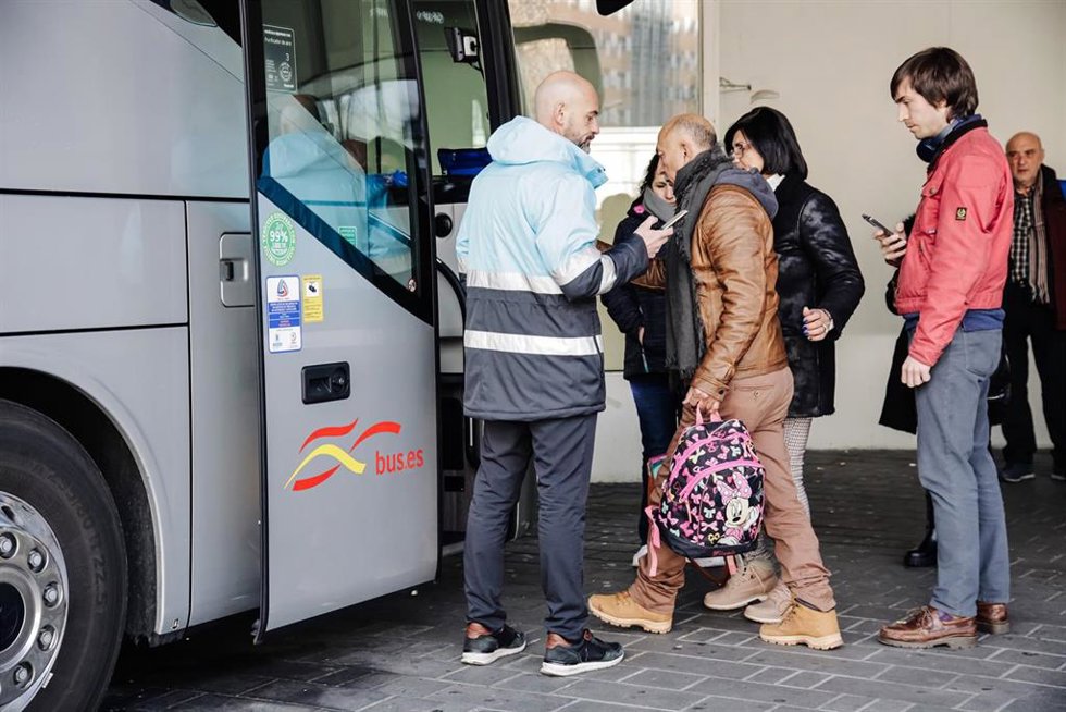 Varias personas sin mascarilla suben a un autocar