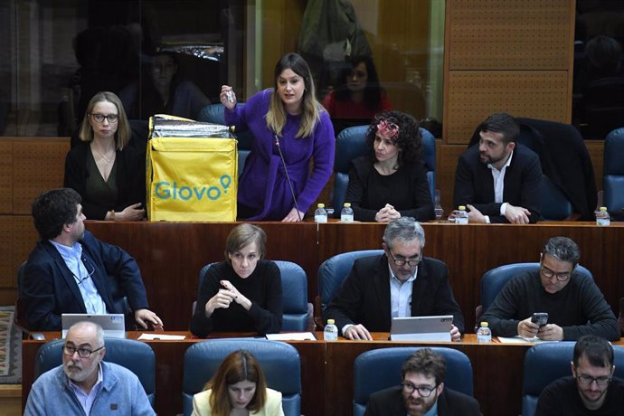 La portavoz de Unidas Podemos en la Asamblea de Madrid, Alejandra Jacinto, saca una mochila de Glovo durante un pleno en la Asamblea de Madrid, a 9 de febrero de 2023, en Madrid (España). 