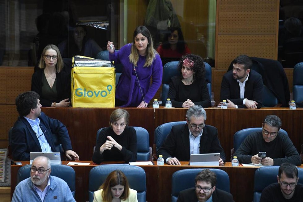La portavoz de Unidas Podemos en la Asamblea de Madrid, Alejandra Jacinto, saca una mochila de Glovo durante un pleno en la Asamblea de Madrid, a 9 de febrero de 2023, en Madrid (España). 