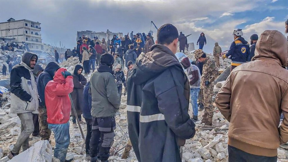 Personas entre los escombros de un edificio destruido tras un terremoto en Siria