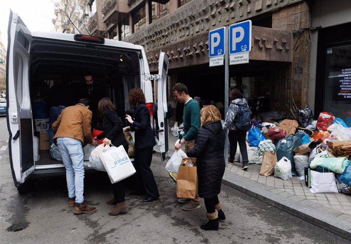 Varias personas meten en el maletero de una furgoneta bolsas  de ropa en una recogida de ayuda humanitaria para los afectados por el reciente terremoto que ha tenido lugar en el sur de Turquía, en la embajada de Turquía