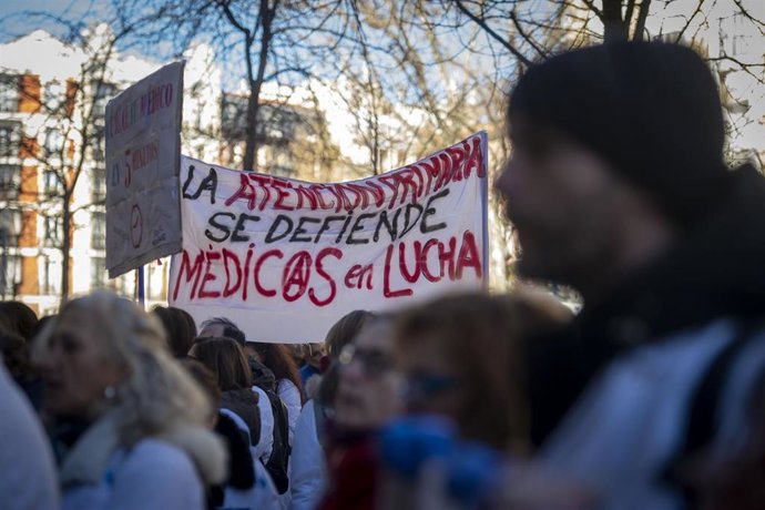 Varias personas marchan, algunas con batas blancas, durante una manifestación convocada por médicos y pediatras de Atención Primaria