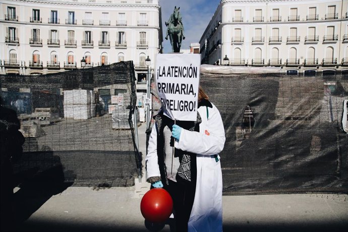 Una mujer protesta con una pancarta que reza '¡La Atención Primaria, en peligro!' durante una concentración de médicos y pediatras de Atención Primaria en huelga, entre la sede de la Dirección General de Recursos Humanos del Servicio Madrileño de Salud 