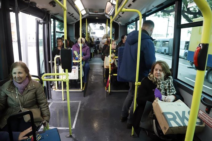 Varias personas con y sin mascarillas en el interior de un autobús urbano