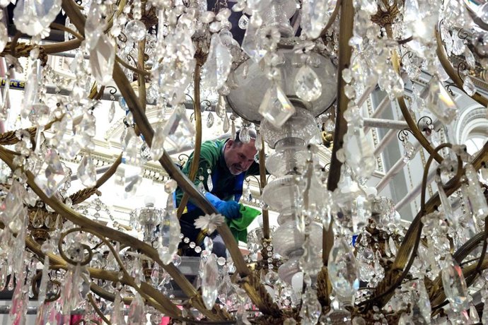 El servicio de mantenimiento del Ayuntamiento de Valncia ha descolgado hoy las dos grandes lámparas de araña colgadas en el Salón de Cristal para proceder a su limpieza.