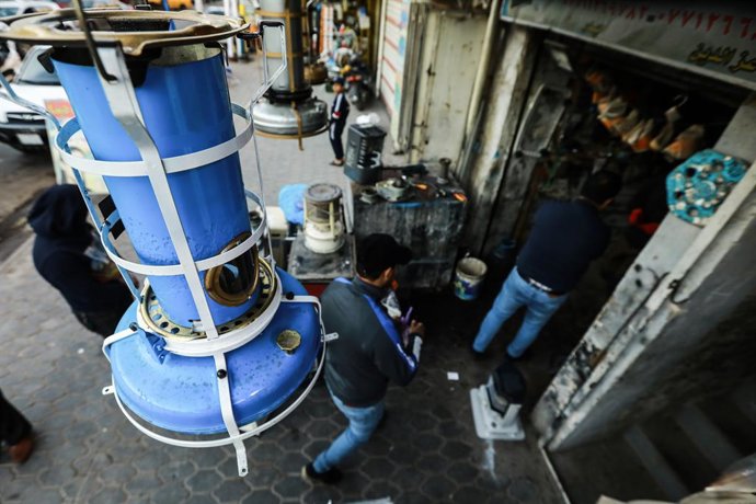 Archivo - 22 January 2022, Iraq, Baghdad: People bring their oil heaters to be fixed at a workshop in Baghdad, as cold winter weather sweeps the country. Severe winter storms are hitting the Middle East region, leaving many areas with unusually low temp