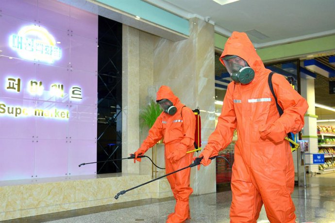 Archivo - HANDOUT - 29 March 2022, North Korea, Pyongyang: A picture provided by the North Korean state news agency (KCNA) on 29 March 2022, shows workers spraying disinfectant at Daesung Department Store as part of anti-COVID efforts. Photo: -/kcna/dpa