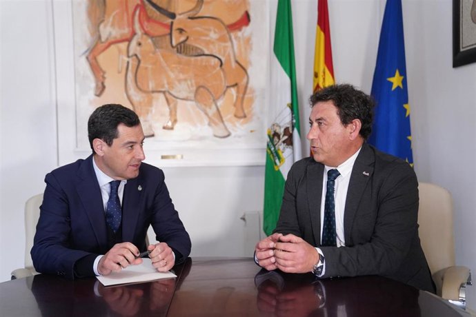 El presidente de la Junta de Andalucía, Juanma Moreno (i), con el alcalde de Cazalla de la Sierra (Sevilla), Sotero Martín, en el transcurso de una visita al municipio.