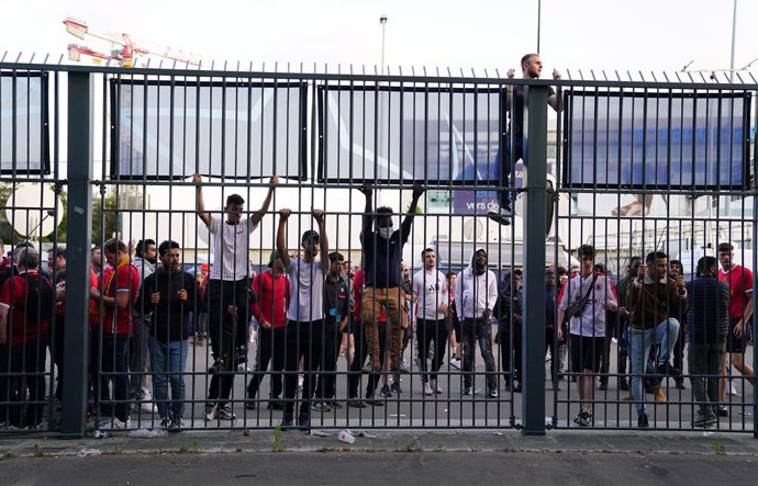 Archivo - 28 May 2022, France, Paris: People try to climb gates outside the ground as the kick off is delayed during the UEFA Champions League final soccer match between Liverpool FC and Real Madrid CF at the Stade de France. Photo: Adam Davy/PA Wire/dpa