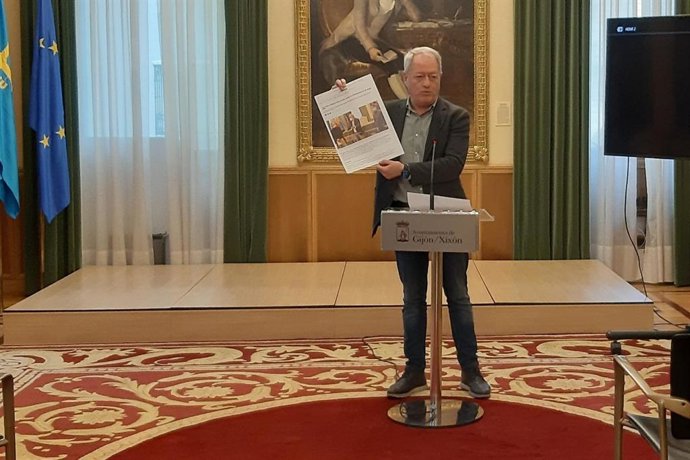Aurelio Martín,  concejal de Medio Ambiente y Movilidad del Ayuntamiento gijonés,  muestra en rueda de prensa la foto del acuerdo con Ciudadanos y la asociación de coches históricos