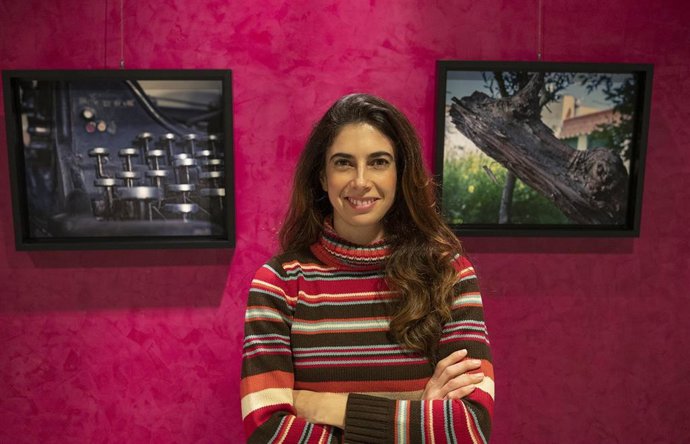 Mariló Jiménez, entre dos de sus fotografías, en la sala de exposiciones del aeropuerto malagueño