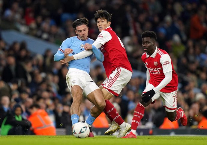 27 January 2023, United Kingdom, Manchester: Manchester City's Jack Grealish (L) and Arsenal's Takehiro Tomiyasu battle for the ball during the English FA Cup forth round soccer match between Manchester City and Arsenal at Etihad Stadium. Photo: Mike Eg