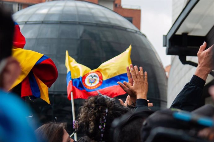 Archivo - Personas ondean una bandera de Colombia
