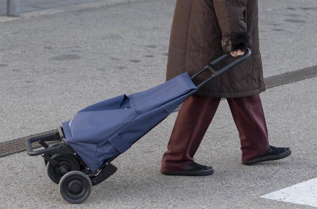 Archivo - Una mujer sale de un supermercado con un carro de la compra, a 27 de diciembre de 2022, en Mejorada del Campo, Madrid (España). El Gobierno ha suprimido durante seis meses el IVA del 4% que se aplica a todos los alimentos de primera necesidad, e