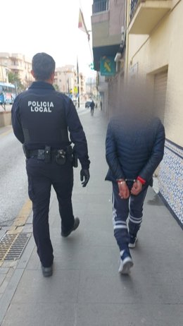 Un policía de Maracena junto a uno de los detenidos.