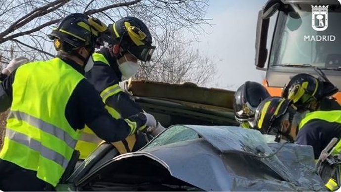 Bomberos del Ayuntamiento de Madrid tratando de rescatar a un hombre tras chocar su coche contra un camión en Valdemingómez