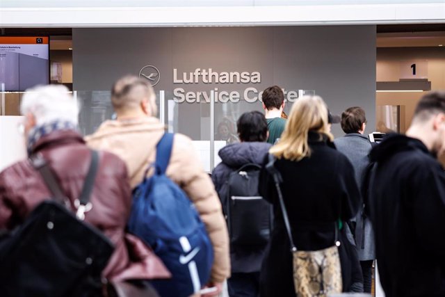 Pasajeros esperan frente a un mostrador de información de Lufthansa en el aeropuerto de Múnich tras el fallo informático.