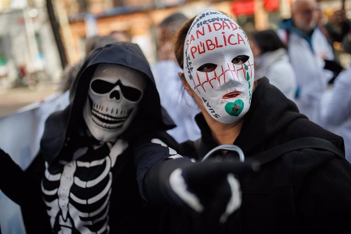 Dos personas con máscaras protestan durante una concentración de médicos y pediatras de Atención Primaria, por el centro de Madrid, a 15 de febrero de 2023