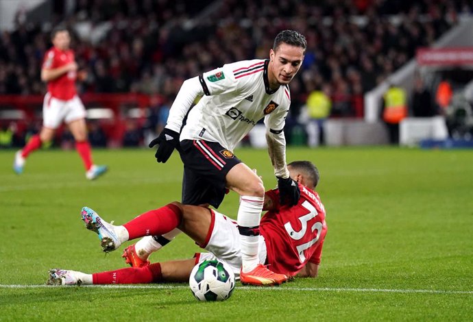 25 January 2023, United Kingdom, Nottingham: Manchester United's Antony and Nottingham Forest's Renan Lodi battle for the ball during the English Carabao Cup semi-final first leg match between Nottingham Forest and Manchester United at the City Ground s