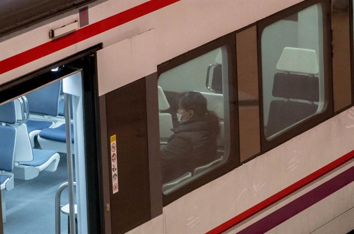 Una mujer con mascarilla dentro de un tren de Cercanías, en la estación Puerta de Atocha-Almudena Grandes
