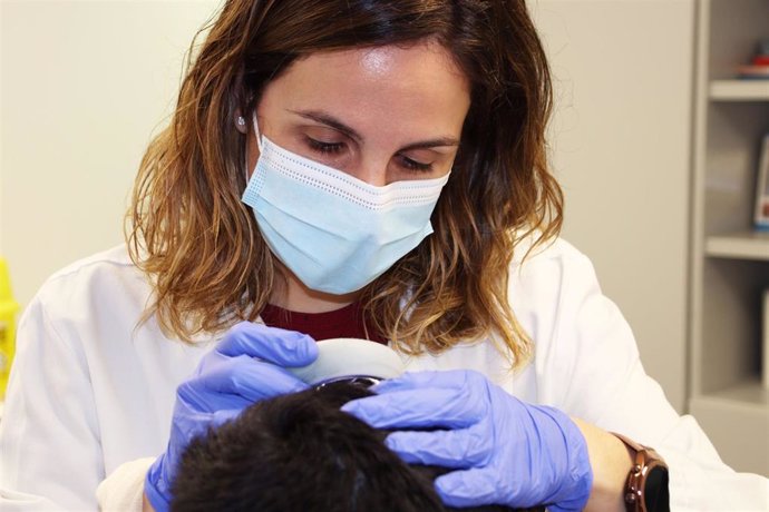 Una dermatóloga revisa el cuero cabelludo
