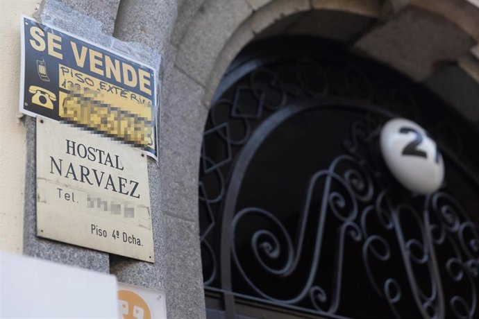 Archivo - Un cartel de 'Se vende' pegado en un portal