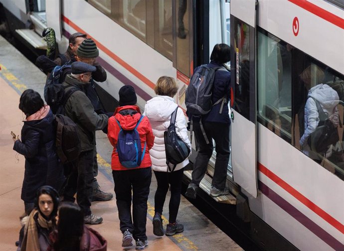 Varias personas sin mascarilla se suben a un vagón de un tren en la estación Puerta de Atocha-Almudena Grandes, a 8 de febrero de 2023, en Madrid (España).