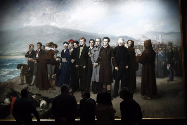 Archivo - Visitantes frente al cuadro 'Fusilamiento de Torrijos y su compañeros en las playas de Málaga', en el Museo del Prado de Madrid