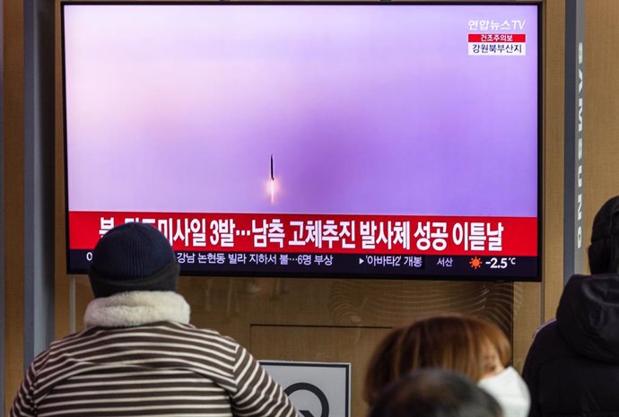 Archivo - 31 December 2022, South Korea, Seoul: People watch breaking news about North Korea's firing of three short-range ballistic missiles into the East Sea on a television installed at Seoul Station in central Seoul. Photo: -/YNA/dpa