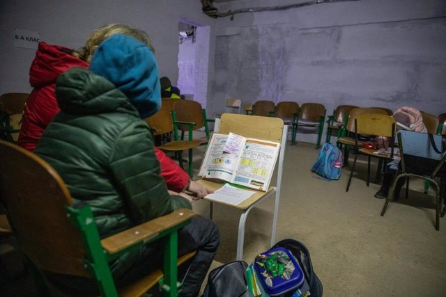 Una maestra explica las tareas a un estudiante mientras se refugia en el sótano de una escuela durante una alerta aérea en la región de Chernígov, Ucrania.