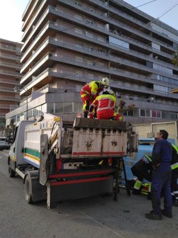 Los bomberos liberan a un operario cuya mano quedó atrapada en la cuba de un camión