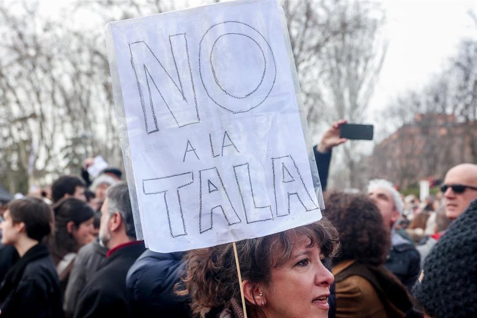 Una mujer porta una pancarta que reza 'No a la tala' en la concentración para defender la arboleda de la zona de Madrid Río
