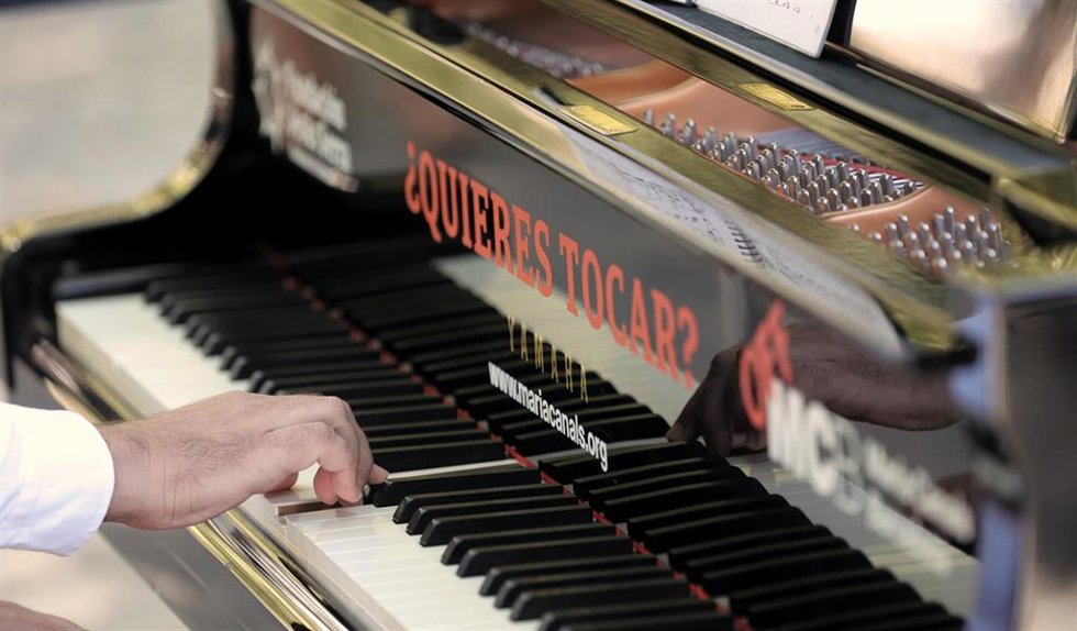 Archivo - Un hombre toca uno de los pianos de cola