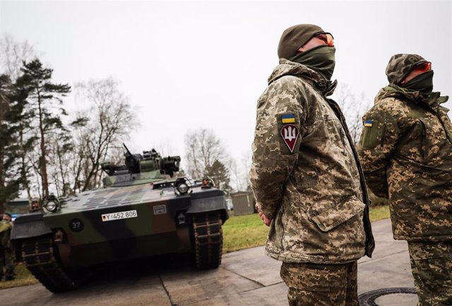 20 February 2023, Lower Saxony, Munster: Ukrainian soldiers Vitalii (R) and Anatolii stand in front of a Marder infantry fighting vehicle during a visit by German Defence Minister Pistorius to the Tank Troop School. Photo: Christian Charisius/dpa
