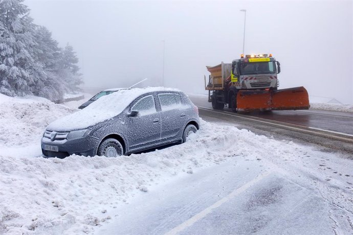 Archivo - Un coche cubierto de nieve y una máquina quitanieves en la carretera de acceso al Puerto de Navacerrada, a 19 de enero de 2023, en Navacerrada, Madrid (España). La Agencia de Seguridad y Emergencias de la Comunidad de Madrid (ASEM 112) ha acti