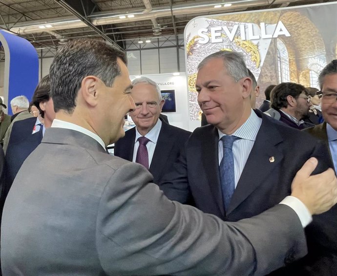 Archivo - El presidente de la Junta, Juanma Moreno, saluda a José Luis Sanz, candidato del PP a la Alcaldía de Sevilla en Fitur.