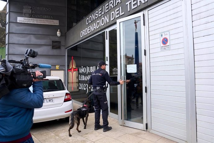 Un agente de la Policía Nacional entra con un perro a las dependencias de la Consejería de Obras Públicas