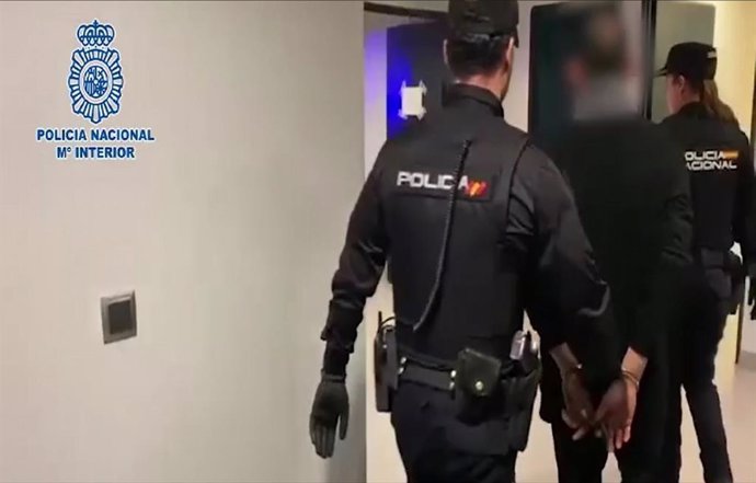 Agentes de Policía Nacional custodian a uno de los detenidos.