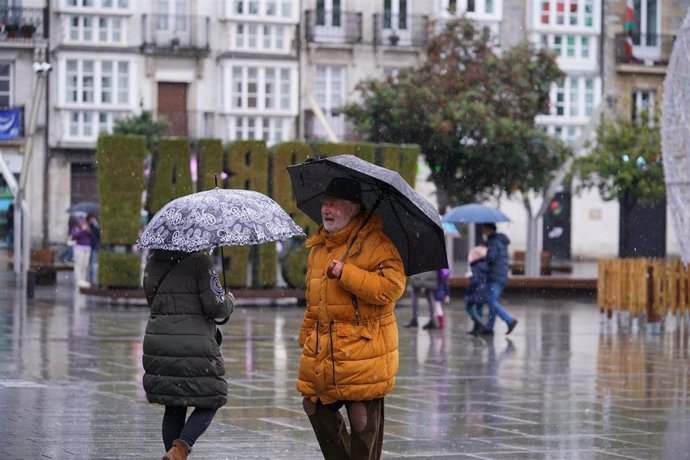 Archivo - Ciudadanos caminan mientras llueve en Vitoria, Euskadi