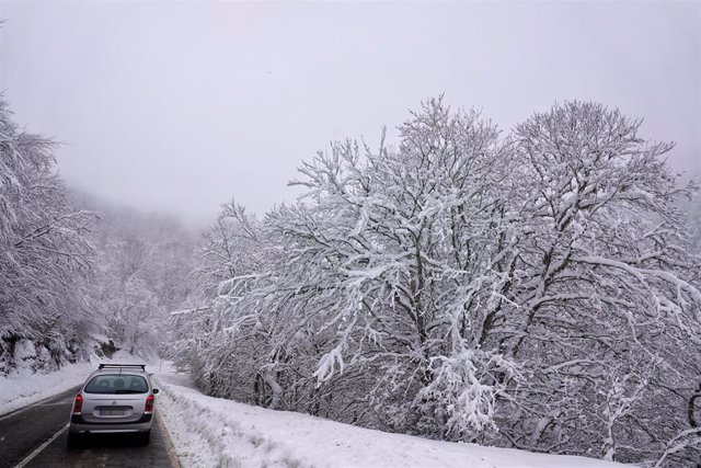 Un vehículo sube por la carretera nevada