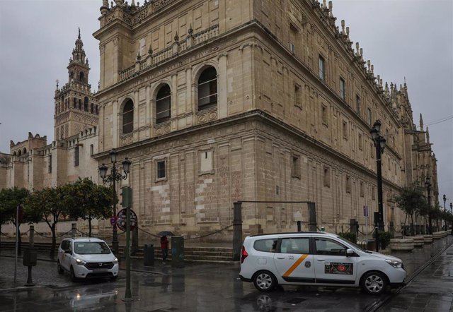 Archivo - Dos taxis cruzan por la avenida de la Constitución en Sevilla. 