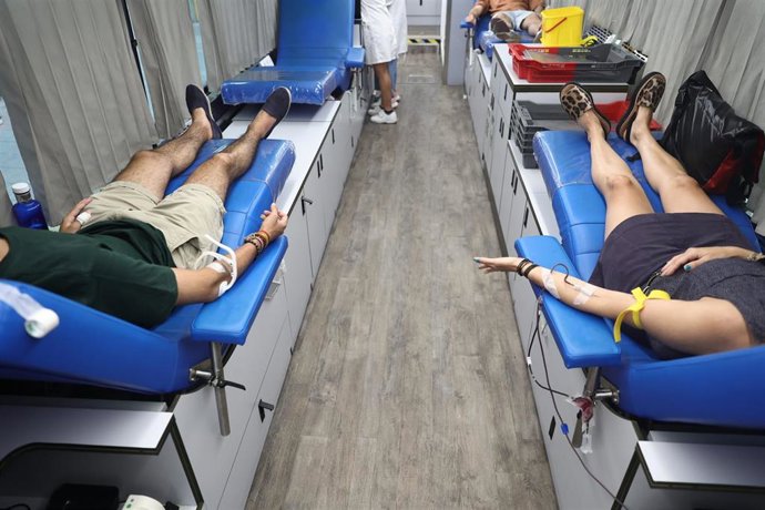 Archivo - Dos personas donan sangre.