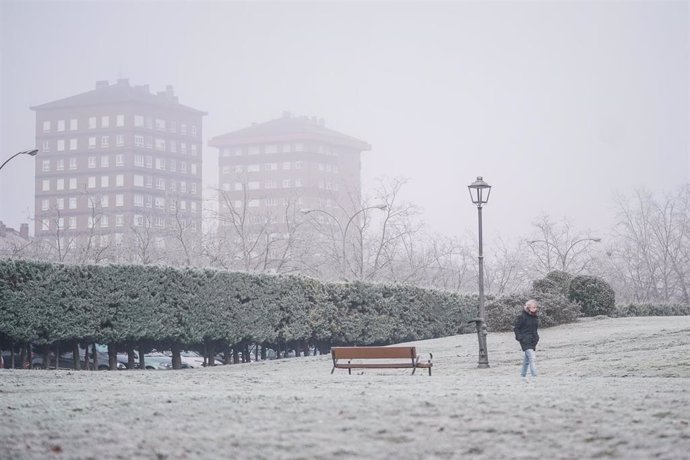 Una persona camina sobre un césped cubierto de nieve, a 9 de febrero de 2023, en Vitoria-Gasteiz, Álava, País Vasco (España). La Agencia Estatal de Meteorología (AEMET) ha activado la alerta amarilla por nevadas en Vitoria-Gasteiz. La jornada ha comenza