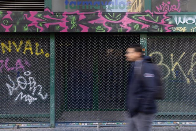 Archivo - Una persona pasa por delante de un comercio cerrado, a 15 de diciembre de 2022, en Madrid (España). La Asociación Madrileña de Trabajadores Autónomos (AMTAS-UPTA) ha alertado hoy de la pérdida de más de 15.000 pequeños comercios en 2023 debido a